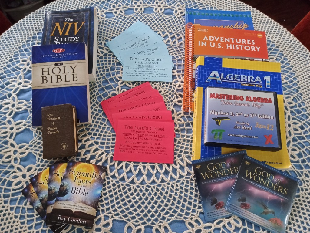 Bibles, homeschool materials, Christian books, and The Lord’s Closet merchandise certificates arranged on a table